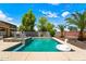 Inviting backyard pool with mature palm trees and lounge area, ideal for relaxation at 14916 W Georgia Dr, Surprise, AZ 85379
