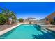 Sparkling pool with waterfall feature and lush tropical landscaping offers a backyard oasis at 14916 W Georgia Dr, Surprise, AZ 85379
