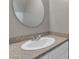 Bathroom vanity features granite countertop, oval sink, and brushed nickel faucet with a large, round mirror at 1601 N Saba St # 308, Chandler, AZ 85225