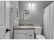 Clean bathroom with a white vanity, speckled countertop, white toilet, and a framed mirror and lights at 1601 N Saba St # 308, Chandler, AZ 85225