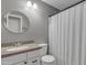 Clean, well-lit bathroom featuring a round mirror and vanity with a speckled countertop and a white shower curtain at 1601 N Saba St # 308, Chandler, AZ 85225