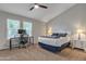 This bright bedroom offers two windows, plush carpet, a ceiling fan, and space for a desk and a king-sized bed at 1601 N Saba St # 308, Chandler, AZ 85225