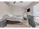Comfortable bedroom with a ceiling fan, a standing mirror, neutral-toned decor, and workspace near the window at 1601 N Saba St # 308, Chandler, AZ 85225