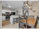 Open-concept dining area boasts a modern light fixture, counter seating and views into the bright white kitchen at 1601 N Saba St # 308, Chandler, AZ 85225