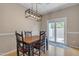 Dining room features a modern light fixture, wood table with seating for four and sliding glass doors to the patio at 1601 N Saba St # 308, Chandler, AZ 85225