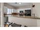 This eat-in kitchen has bar seating, stainless steel appliances, granite countertops and a sleek black refrigerator at 1601 N Saba St # 308, Chandler, AZ 85225