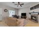 Bright living room with hardwood floors, a stone fireplace, and a ceiling fan at 1601 N Saba St # 308, Chandler, AZ 85225