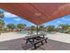 Inviting poolside featuring a picnic table under a shade awning for outdoor dining and leisure at 1601 N Saba St # 308, Chandler, AZ 85225