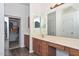 Bright bathroom featuring a vanity, dual mirrors, and wood look flooring at 16112 W Durango St, Goodyear, AZ 85338