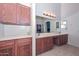Bathroom featuring a double sink vanity, a large mirror, and ample cabinet space at 16112 W Durango St, Goodyear, AZ 85338