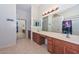 Bright bathroom featuring a large mirror, double sinks, and a separate shower, offering a functional design at 16112 W Durango St, Goodyear, AZ 85338