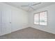 Bright bedroom features neutral carpet, a ceiling fan, and a window with wooden blinds at 16112 W Durango St, Goodyear, AZ 85338