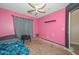 Bedroom with pink walls, a ceiling fan, and natural light, perfect for customization at 16112 W Durango St, Goodyear, AZ 85338