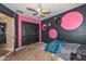 Unique bedroom with pink and black walls, a ceiling fan, and a spacious closet at 16112 W Durango St, Goodyear, AZ 85338