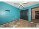 A bedroom featuring blue walls, a ceiling fan, and a closet, ready for customization at 16112 W Durango St, Goodyear, AZ 85338