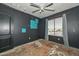Bedroom featuring dark walls and ceiling fan with damaged floors at 16112 W Durango St, Goodyear, AZ 85338