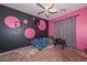 Eclectic bedroom with pink and black walls, a ceiling fan, and space for personalization at 16112 W Durango St, Goodyear, AZ 85338