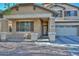 View of the front of the home showcasing the cozy covered porch and a view of the two-car garage at 16112 W Durango St, Goodyear, AZ 85338
