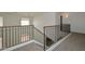 Second floor hallway with carpet and dark metal railing at 16112 W Durango St, Goodyear, AZ 85338