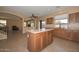 Spacious kitchen with an island, wood cabinets, and connection to the living area at 16112 W Durango St, Goodyear, AZ 85338