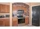 Kitchen with stainless steel microwave and range, with brick archway at 16112 W Durango St, Goodyear, AZ 85338