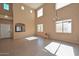 Open living room featuring a tall ceiling, multiple windows and tile floors and neutral colored walls at 16112 W Durango St, Goodyear, AZ 85338