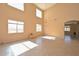 Spacious living room featuring a tall ceiling, multiple windows and tile floors and neutral colored walls at 16112 W Durango St, Goodyear, AZ 85338