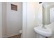 Small powder room with pedestal sink, toilet, and window at 16112 W Durango St, Goodyear, AZ 85338