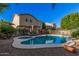 Backyard with a sparkling pool, mature desert landscaping, privacy fence, and patio space at 16153 W Lisbon Ln, Surprise, AZ 85379