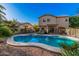 Expansive backyard featuring a sparkling pool, landscaping, and a spacious patio area at 16153 W Lisbon Ln, Surprise, AZ 85379