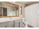 Bathroom featuring a large mirror with a wood frame, modern vanity, and shower with curtain at 16153 W Lisbon Ln, Surprise, AZ 85379