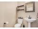 Cozy half bathroom with decorative shelving, pedestal sink, and rustic mirror at 16153 W Lisbon Ln, Surprise, AZ 85379