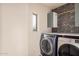 Laundry room with front load washer and dryer with designer wallpaper at 16153 W Lisbon Ln, Surprise, AZ 85379