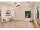 Bright, airy living room featuring tile floors, a ceiling fan, and great natural light through a large window at 16153 W Lisbon Ln, Surprise, AZ 85379