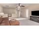 Large living room with a brown sectional sofa and TV on a stand with decorative fireplace at 16153 W Lisbon Ln, Surprise, AZ 85379