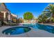 Backyard features a pool and spa surrounded by mature desert landscaping and seating at 16153 W Lisbon Ln, Surprise, AZ 85379