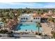 Aerial view of the pool area with a swimming pool, palm trees, and clubhouse at 1633 E Lakeside Dr # 39, Gilbert, AZ 85234