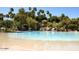 Large, lagoon-style pool with sandy beach area, lush landscaping, and gazebo at 1633 E Lakeside Dr # 39, Gilbert, AZ 85234