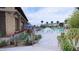 A serene pool area with landscaping, umbrellas, lounge chairs, and a view of the pool at 16932 W Desert Hollow Dr, Surprise, AZ 85387