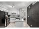 Updated kitchen features white cabinets, black appliances and a granite-topped island, plus peek into bedroom at 19820 N 13Th Ave # 255, Phoenix, AZ 85027