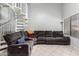 Bright and inviting living space with a spiral staircase, a gray sectional couch, and large windows at 19820 N 13Th Ave # 255, Phoenix, AZ 85027