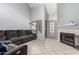 Spacious living room with a comfortable gray sofa, tile floors, fireplace and bright window at 19820 N 13Th Ave # 255, Phoenix, AZ 85027