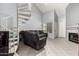 Bright living room with spiral staircase, corner fireplace, gray sectional sofa, and tile flooring at 19820 N 13Th Ave # 255, Phoenix, AZ 85027