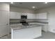 Bright kitchen featuring white cabinetry, stainless steel appliances, a center island, and granite countertops at 2025 E Bucking Bronco Dr, San Tan Valley, AZ 85140