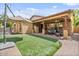 Backyard features a covered patio, green turf, an umbrella, and outdoor seating, perfect for relaxing and entertaining at 21014 W Cora Vista --, Buckeye, AZ 85396