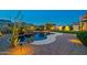Stunning backyard pool area with a unique design, rock waterfall, and lush landscaping, creating a serene outdoor oasis at 21104 W Sage Hill Rd, Buckeye, AZ 85396