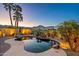 Relaxing backyard pool with rock waterfall, mature palm trees, and decorative lighting, creating a tranquil outdoor retreat at 21104 W Sage Hill Rd, Buckeye, AZ 85396