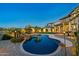 Lush backyard featuring a custom pool, tranquil rock waterfall, and patio for entertaining beneath professionally designed lighting at 21104 W Sage Hill Rd, Buckeye, AZ 85396