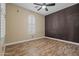 Bright bedroom with wood-look flooring and large window with shutter coverings at 21104 W Sage Hill Rd, Buckeye, AZ 85396