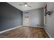 Minimalist bedroom with wood-look floors, simple window covering and ceiling fan at 21104 W Sage Hill Rd, Buckeye, AZ 85396